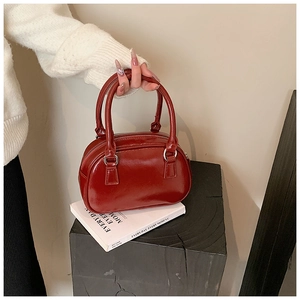 Detailed view of red glossy bowling bag with top handles and metallic zipper closure