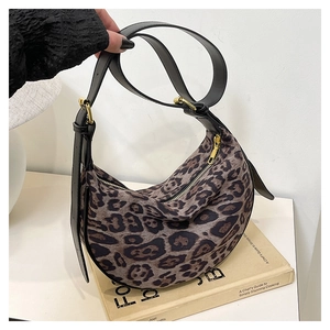 Close-up of leopard print crossbody bag with plush texture and adjustable leather strap