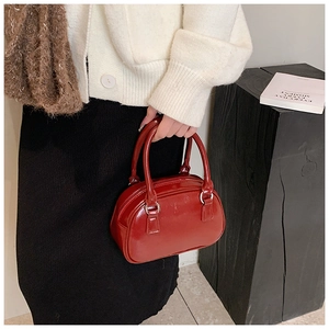 Detail of red glossy mini bowling bag with silver hardware and dual handles