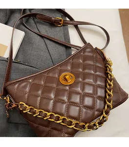 Detailed view of brown quilted bag with gold chain strap and metallic twist lock closure