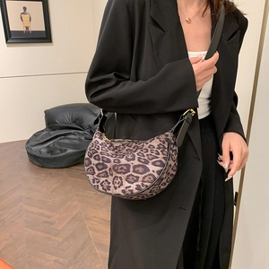 Vintage leopard print hobo bag with gold hardware and black trim worn by a model