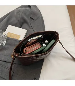 Detail view showing large internal capacity of brown quilted leather bucket bag