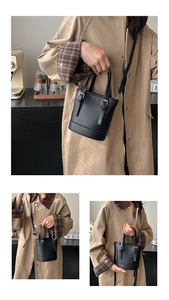 Détails du mini sac seau noir grainé avec poignée fixe et bandoulière amovible
