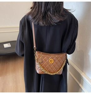 Detailed side view of brown quilted crossbody bag with gold chain and metal twist lock