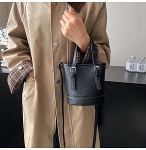 Détail du sac seau noir grainé avec boucles argentées et fine bandoulière en cuir