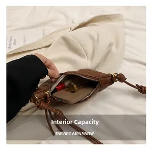 Interior view showing capacity of a brown pebbled leather crossbody bag with items