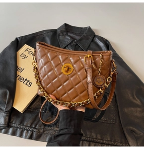 Detail of brown quilted leather shoulder bag with gold chain strap and turn-lock buckle