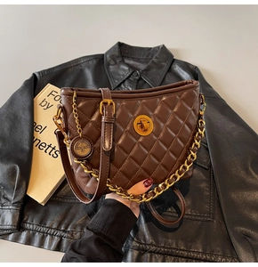 Close-up of brown quilted leather bag featuring a gold twist lock and logo charm