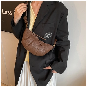 Detail of a brown lychee pattern leather croissant bag showing segmented stitching and texture