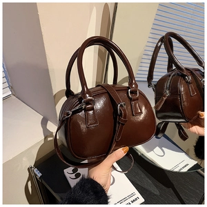 Macro detail of dark brown glossy leather handbag with vintage silver zipper hardware
