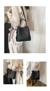Close-up of black lychee texture bucket bag featuring metal handles and shoulder strap