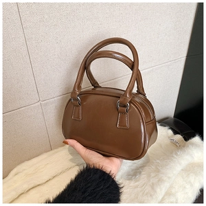 Detailed view of the dark brown glossy PU leather mini Boston bag with silver hardware