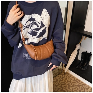 Brown lychee leather crescent crossbody bag featuring a stylish knotted shoulder strap detail