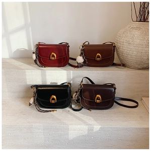 Detailansicht der Vintage-Satteltaschen in vier Farben mit goldenen Schnallen und Anhängern