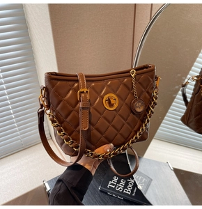 Detailed close-up of brown quilted bucket bag with gold chain and circular lock