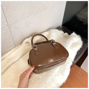 Top-down view of a stylish brown PU leather bowling handbag with silver hardware details