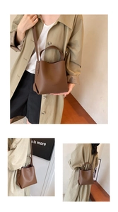 Detail of a dark brown lychee leather bucket bag with top handle and adjustable strap
