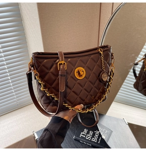 Detail of deep brown quilted shoulder bag with golden twist lock and chunky chain