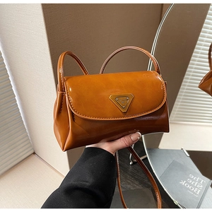Detail of vintage brown leather pillow bag featuring a classic triangular metal logo