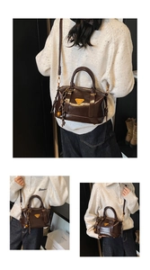 Detail of dark brown glossy handbag showing gold triangle logo and bell charm accessory