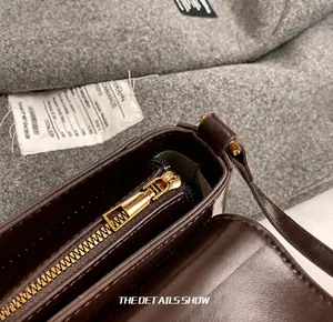 Nahaufnahme des goldenen Reißverschlusses an einer dunkelbraunen Glattleder-Schultertasche