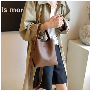 Detailed texture of brown pebble leather bucket bag with top handle and shoulder strap
