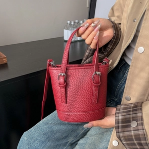 Mini sac seau en cuir grainé rouge avec poignées et détails de boucles argentées