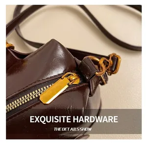 Close-up of premium golden zipper hardware on a glossy vintage brown leather handbag
