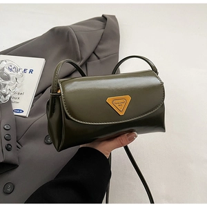 Close-up of olive green oil wax leather pillow bag with gold triangle logo detail