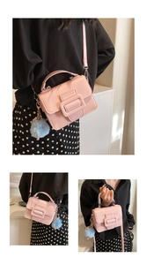 Dettaglio borsa quadrata rosa in pelle PU con fibbia grande e ciondolo a pompon blu