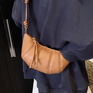 Brown lychee leather croissant crossbody bag with signature stitched panel design