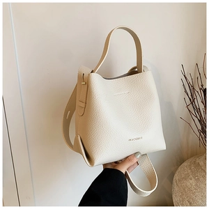 Detailed macro view of the cream-colored lychee pattern leather bucket bag and handle