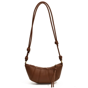 Deep brown lychee pattern leather croissant bag with adjustable knotted strap on white back