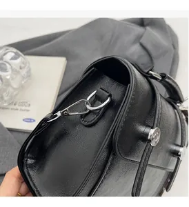 Macro detail of glossy black leather bag with premium silver-tone hardware and metal D-ring