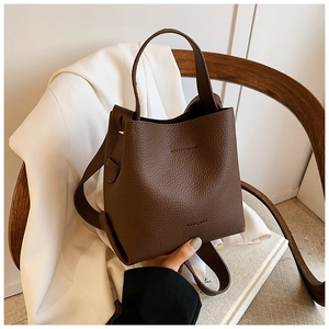 Detail of dark brown leather bucket bag with textured finish and brand logo