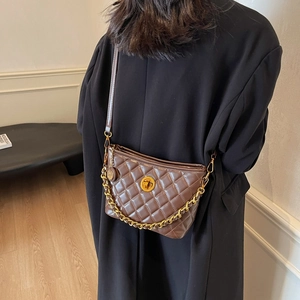 Brown quilted crossbody bag with gold chain strap and rotary lock shown from behind