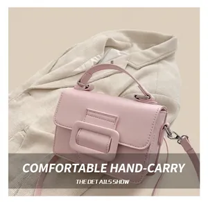 Dettaglio della borsa a mano rosa con fibbia quadrata decorativa e manico tondo
