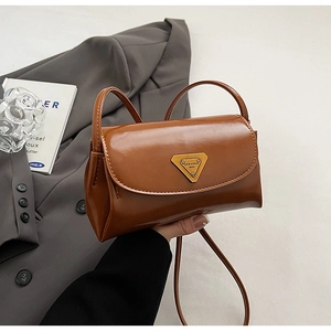 Detail of vintage oil wax leather brown crossbody bag with gold triangular buckle