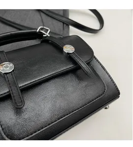 Detailed view of the black lychee pattern leather bag and silver metal buckle