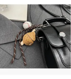 Close-up of sports keychain with mini baseball bat and glove on a black leather strap
