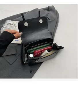 Spacious interior of black PU leather shoulder bag with zipper pocket and dual magnetic closure