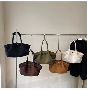 Collection de grands sacs cabas en daim de diverses couleurs neutres suspendus en studio