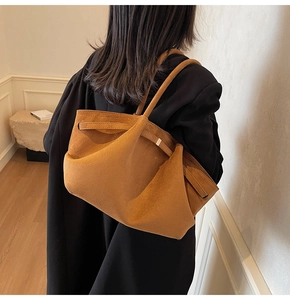 Détail du cabas en daim caramel avec ceinture décorative et boucle métallique élégante