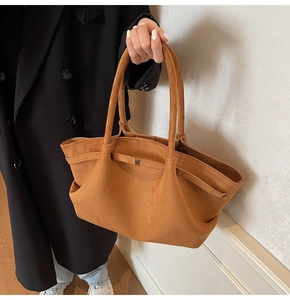 Détail du sac cabas en daim avec lanière en cuir et boucle métallique dorée carrée
