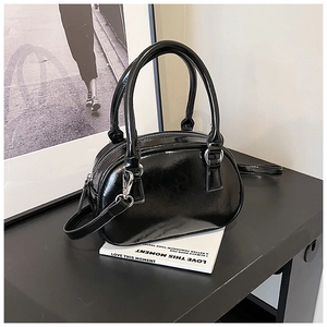 Detailed macro view of the glossy black bowling bag featuring silver metallic buckles