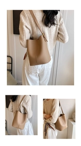 Détail du sac seau en cuir beige à motif litchi avec boucle dorée et bandoulière