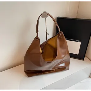 Macro shot of large capacity brown glossy leather shoulder bag with sleek textured finish