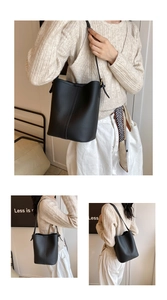 Vue détaillée du sac seau en cuir noir grainé avec pendentif latéral et texture raffinée