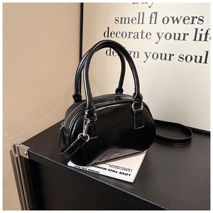 Detailed view of black glossy bowling bag with silver hardware and adjustable strap