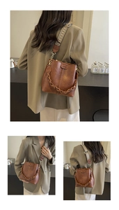 Detail view of brown leather bucket bag featuring a woven chain and geometric wide strap